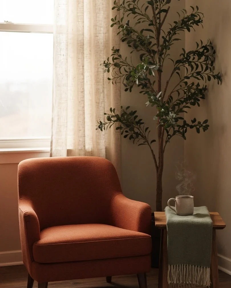 A calm one-to-one therapy room with a warm armchair beside a sunlit window at Tansem Psychology in Leduc, Alberta.